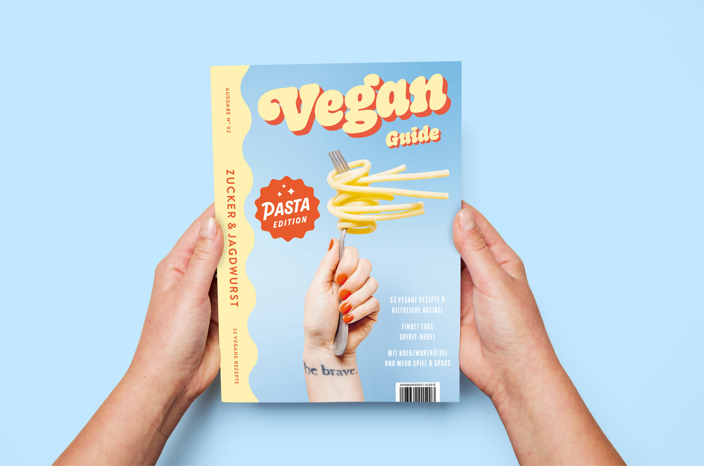 Kochbuch ‚Pasta Guide‘ auf blauem Hintergrund wird von Händen gehalten