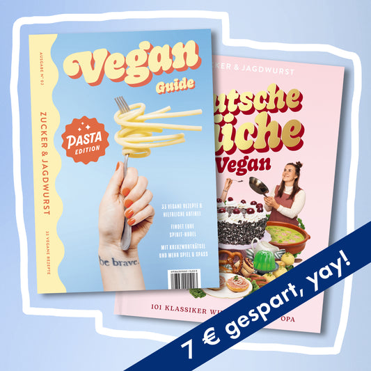 Zwei Kochbücher: links vorne ‚Pasta Guide‘ mit blauem Cover und gelbem Schriftzug, rechts hinten ‚Deutsche Küche Vegan‘ mit rosa Cover, rechts unten mit blauem Spar-Banner