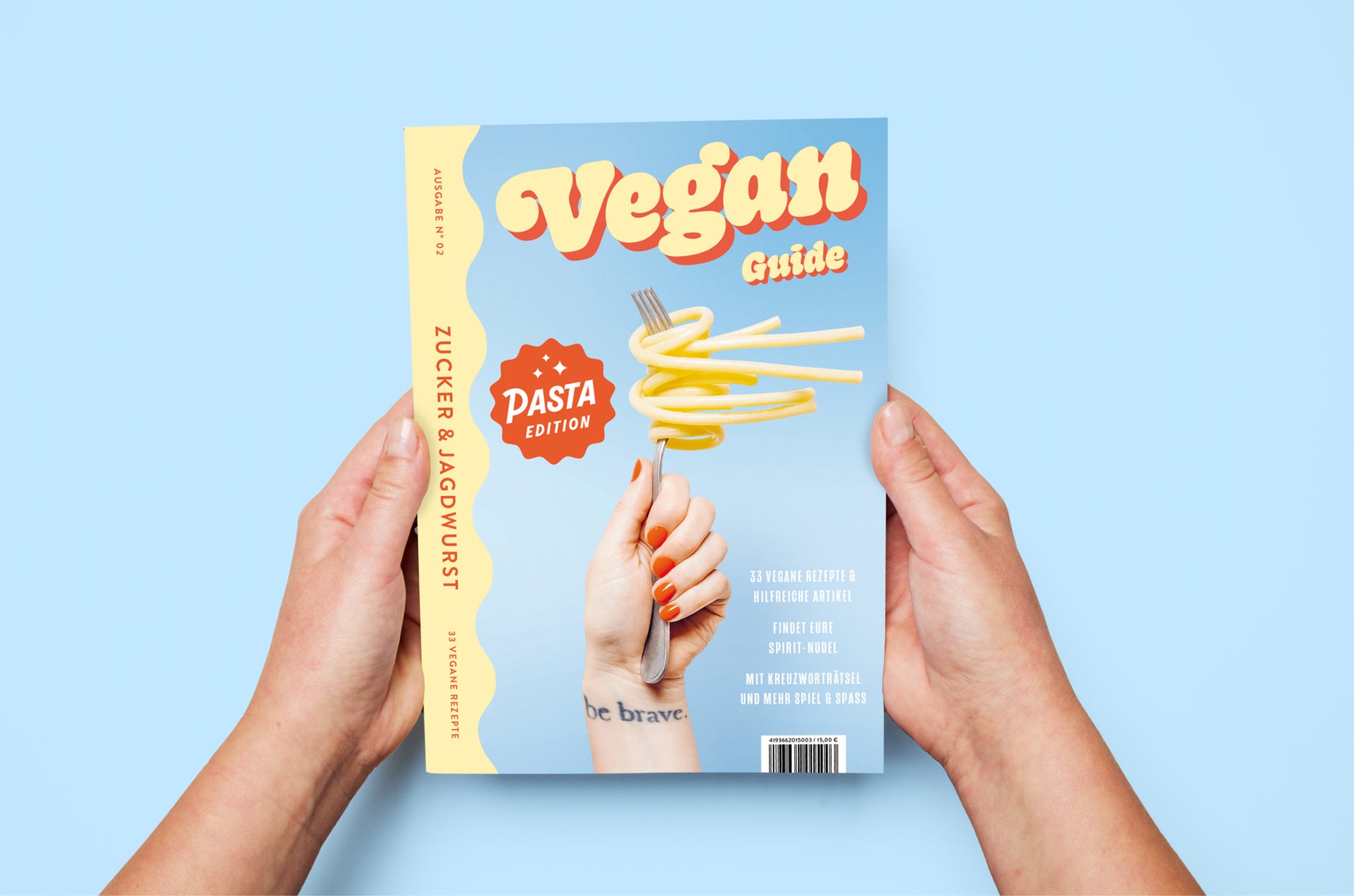 Kochbuch ‚Pasta Guide‘ auf blauem Hintergrund wird von Händen gehalten