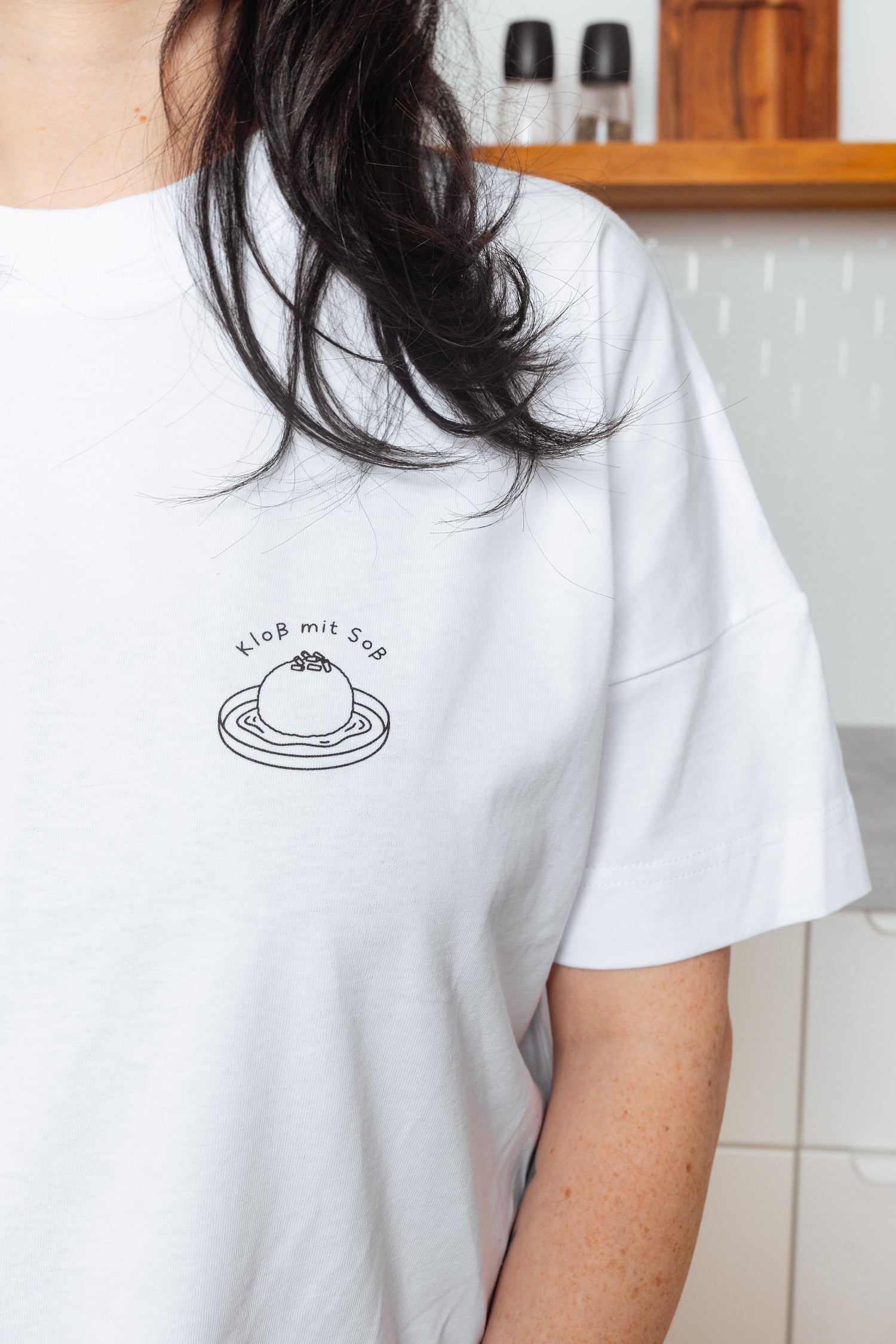 Detailaufnahme vom weißen T-Shirt mit schwarzer “Kloß mit Soß” Illustration