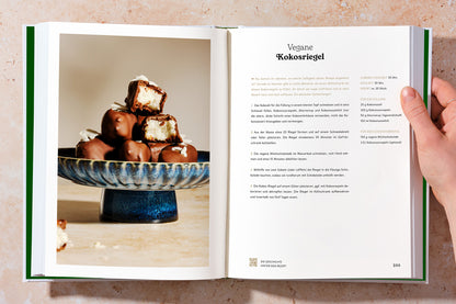 Zwei Innenseiten des Kochbuchs ‚Vegan durch den Tag’: rechts der Rezepttext, links ein Bild der veganen Kokosriegel